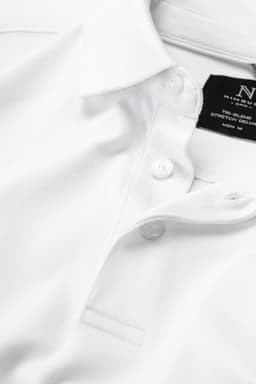 A white polo shirt featuring a button collar, with a brand logo on the inner tag.