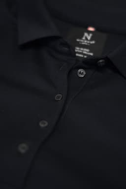 A dark navy polo shirt with a collar and button detail, featuring a logo on the label inside.