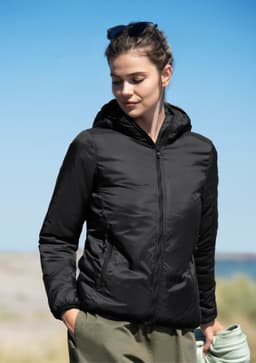 A black women's jacket with a hood, worn by a woman outdoors, against a blue sky background.
