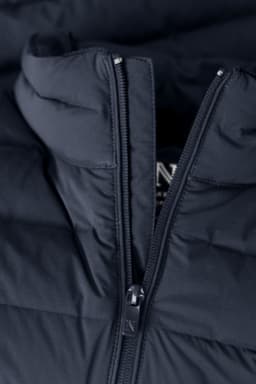 A navy blue down jacket with a zippered front and a hood, featuring a branding logo.