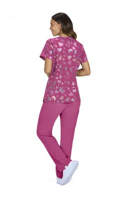 A pink scrubs set featuring a heart-patterned top and solid pink pants, paired with white footwear.