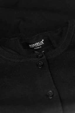 A black cardigan with a round neckline and button detailing, featuring a label inside.