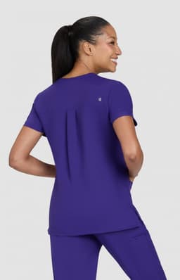 A purple women's top is worn by a model from a rear view, featuring short sleeves and a relaxed fit.