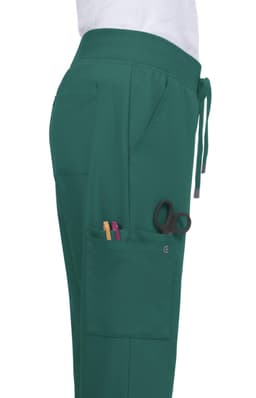 Atria Pant in teal, featuring pockets with pens and scissors, shown from the side. Includes a drawstring waistband.