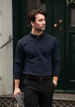 A navy blue polo shirt with a collar and button placket, modelled by a man in smart casual attire, holding a jacket.