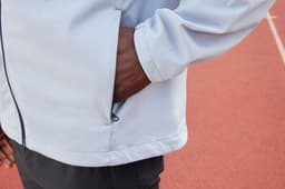 A grey men's softshell jacket with a zip pocket, featuring a close-up of the cuff and side.