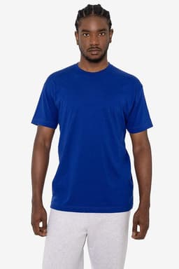 A model wearing a blue short sleeve cotton poly crew tee alongside light grey trousers. The shirt features a logo.