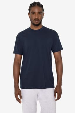 A navy short sleeve cotton-poly crew tee on a model, featuring a simple design and a logo.