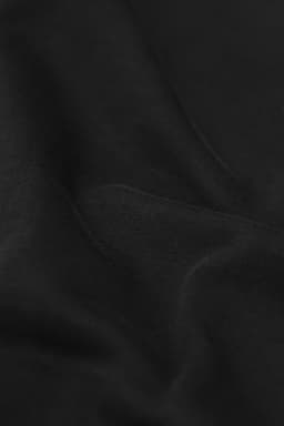A black sweatshirt displaying soft fabric texture with subtle folds and a logo.