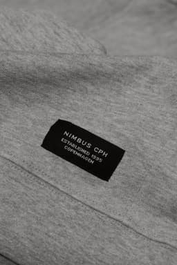 A grey sweatshirt featuring a label with branding details at the neckline.