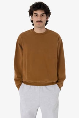 A man wears a brown heavy fleece pullover paired with grey sweatpants. The pullover has a simple design and logo.