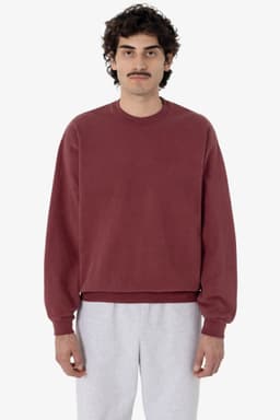 A maroon garment dye heavy fleece pullover with a relaxed fit and long sleeves, worn by a model.