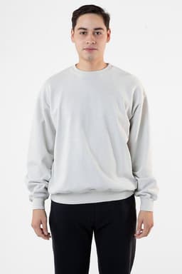 A man wearing a light grey garment dye heavy fleece pullover, standing against a plain background.