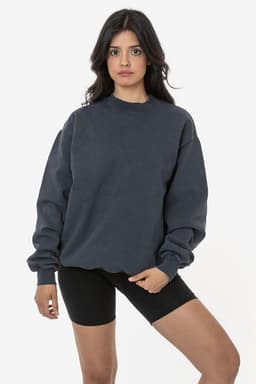 A woman wearing a dark grey heavy fleece pullover and black bike shorts, posing against a plain background.