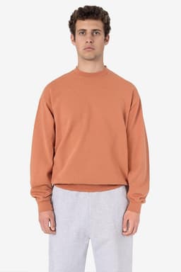 A heavy fleece pullover in a rust orange colour, featuring a relaxed fit and long sleeves. Includes a logo.