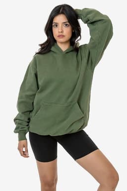 A green heavy fleece hooded pullover with a front pocket, modelled by a person wearing black shorts.