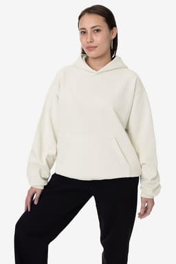 A light cream heavy fleece hooded pullover with a front pocket, worn by a model against a plain background.