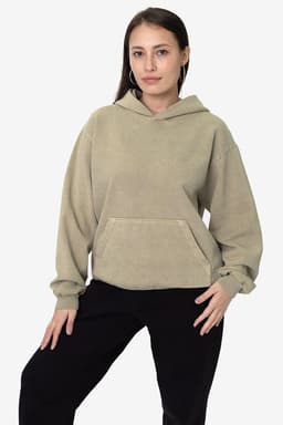 A hooded pullover in beige fleece, featuring a front pocket and a relaxed fit. The model poses against a plain backdrop.