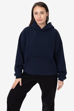 A woman wearing a navy blue Garment Dye Heavy Fleece Hooded Pullover with a front pocket and a relaxed fit.