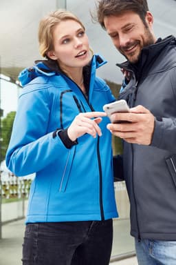 A blue ladies' winter softshell jacket features a hood and zippers, displayed alongside a grey jacket.