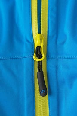 A close-up of a blue outdoor jacket featuring a yellow zipper and pull tab, with a logo present.