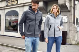 A grey and light grey hooded jacket with zip pockets, worn by a man and woman, both casually dressed.