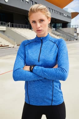 A long-sleeved sports shirt in blue with a zip and fitted design, featuring a logo on the front.