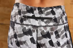 Ladies' 3/4 sports tights in a grey and black abstract pattern, with a back pocket and a logo.