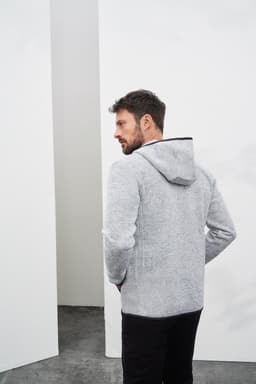 A grey knitted fleece hoodie with a hood, featuring a logo, worn by a man facing away from the camera.