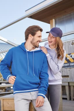 A blue hoodie with white stripes in a casual setting, paired with a light grey hoodie worn by a smiling woman.