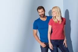 A blue men's V-T shirt and a pink women's V-T shirt are displayed on a light background. Both models are smiling.