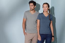 A grey and a navy women's heather T-shirt are displayed on models against a light blue background. The shirts have v-neck designs.