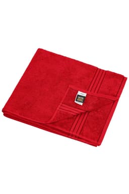 A red sauna sheet with a textured surface and folded corner revealing a label, showcasing a solid colour design.