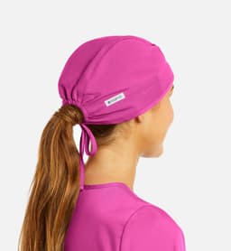A unisex scrub cap in vibrant pink, featuring adjustable ties and a small logo.