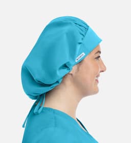 A unisex bouffant scrub cap in bright blue, displayed on a person's head from the side.