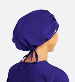 A unisex bouffant scrub cap in vibrant purple, featuring a logo and ties at the back.