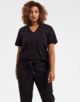 A woman wearing a black tunic with a V-neck and loose sleeves, paired with matching black pants.