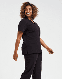 A model wearing a black women's tunic, featuring a V-neck and relaxed fit, alongside matching black pants.