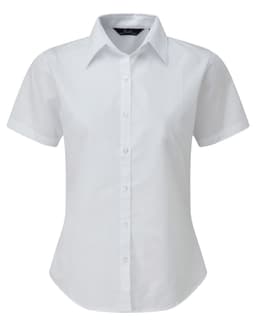 A white short-sleeved women's button-up blouse with a collar and a fitted design. It features a discreet logo.