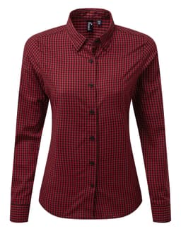 A button-up women's shirt featuring a red and black check pattern with a collar and long sleeves. It has a logo.