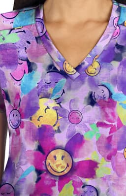 A V-neck top featuring a vibrant purple and floral pattern with smiling face motifs throughout.