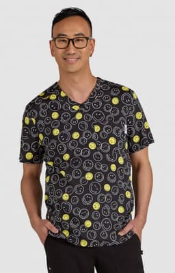 A black top featuring a playful pattern of yellow smiley faces, worn by a man with glasses. The product has a logo.
