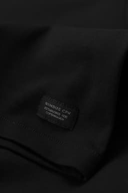 A black t-shirt with a label featuring a logo. The fabric appears smooth and soft.