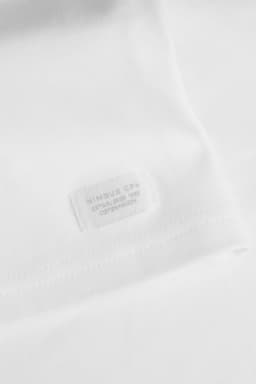 A white men's T-shirt with a brand tag featuring a logo. The fabric appears soft and smooth.
