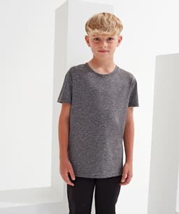 A grey kids' performance t-shirt displayed on a boy against a minimalist background. The shirt has a simple design.