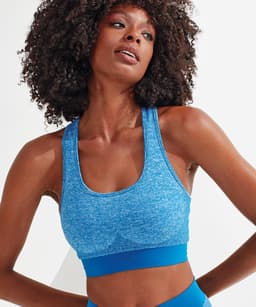 A blue sport bra with a seamless design and a contrasting blue band, featuring a logo.