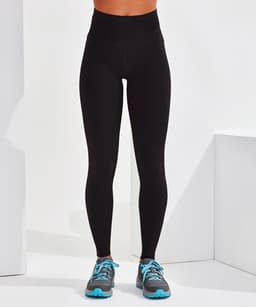 A pair of black seamless leggings displayed on a model, paired with grey and blue athletic shoes.