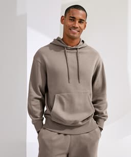 A unisex recycled hoodie in a neutral brown shade features a front pocket and an adjustable drawstring hood.
