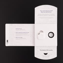 A white Tile Mate tracker packaged inside a recyclable box with a key ring. The box features a logo and instructions.