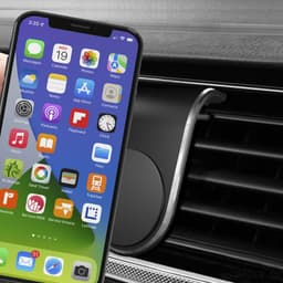 A smartphone in front of a black magnetic car phone holder, designed for air vent installation.